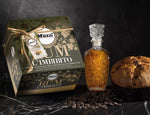 Un panettone al rum in una scatola regalo raffinata, accanto a una bottiglia vintage e chicchi di caffè, su sfondo nero.