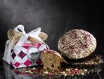 Esclusiva dolcezza natalizia: un panettone artigianale, ricco di crema di pistacchio e lamponi, confezionato a mano.