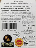 Scopri la confezione di Parmigiano Reggiano DOP Bonat, stagionato 10 anni, con sigilli di qualità ed etichette informative.