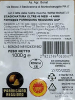 Una confezione da 1kg di Parmigiano Reggiano DOP, stagionato per 48 mesi, con etichette informative.