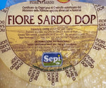 Un formaggio Fiore Sardo DOP stagionato, con crosta naturale, l'etichetta ne conferma gli ingredienti e l'origine certificata.