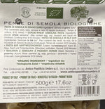 Un pacco trasparente da 500g di penne biologiche realizzate con semola di grano duro, con un'etichetta verde che fornisce dettagli sul prodotto.