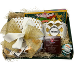 Un cesto natalizio di Roberta, avvolto in paglia dorata, ricolmo di dolciumi italiani, cioccolato balsamico e decorazioni.