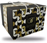 Un panettone tradizionale si presenta in una scatola regalo elegante, con decorazioni geometriche in oro e nero, per un Natale raffinato.