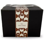 Un'elegante scatola marrone dal design geometrico, contenente un Panettone ai Tre Cioccolati, dotata di un raffinato manico in tessuto bianco.