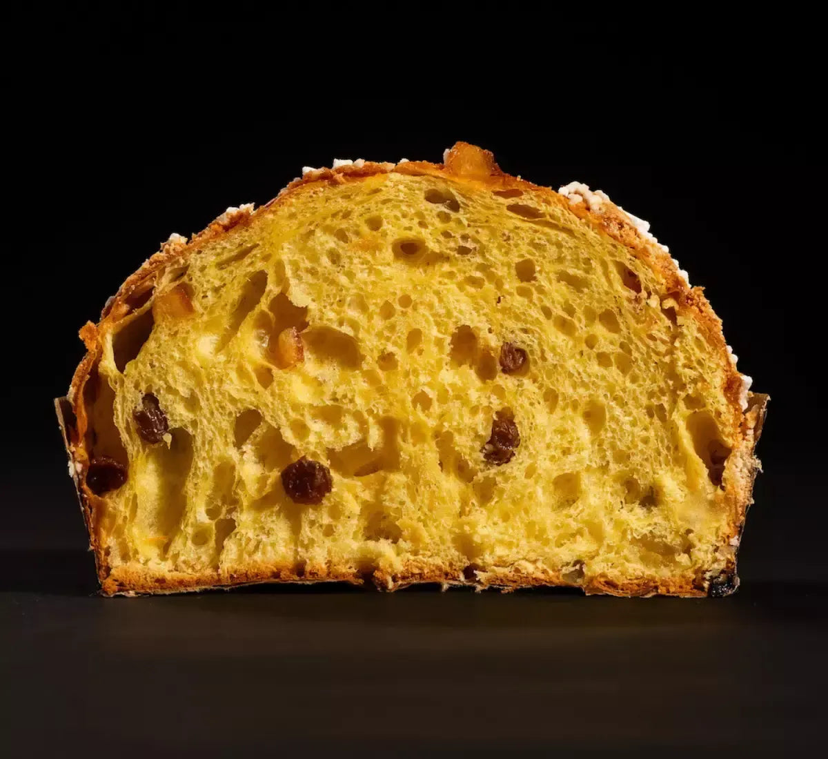 Un panettone tradizionale, lussurioso nel suo essere soffice e dorato, abbellito da frutta candita e uvetta, presentato in una elegante scatola regalo.