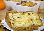 Una fetta di panettone biologico, con uvetta e noci, è elegantemente disposta su un piatto, su un tavolo rustico.