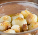 Squisite cipolle Borettane artigianali, immerso in olio e caramellate in agrodolce, presentate in un piatto di vetro.