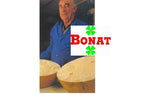 Un anziano casaro mostra con orgoglio le sue forme di Parmigiano Reggiano Bonat, stagionate per più di 22 anni, un emblema della qualità e tradizione italiana DOP.