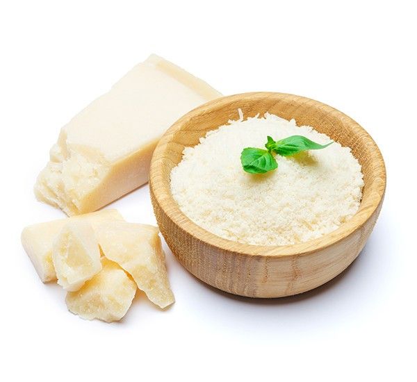 Una ciotola contenente Parmigiano Reggiano DOP grattugiato, arricchito da un rametto verde, accanto a saporite scaglie e un pezzo intero dello stesso formaggio.