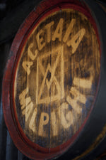 Un barile in legno marchiato con il logo Acetaia Malpighi, emblema della tradizione artigianale del balsamico di Modena.