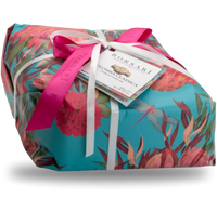 Invito a un'esperienza pasquale dolce con una Colomba Classica, avvolta in nastri rosa e bianchi, all'interno di una confezione colorata a tema floreale.