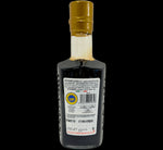 Aceto Balsamico di Modena IGP Gold in una bottiglia raffinata con tappo dorato e un'etichetta dettagliata, pronto per l'assaggio.