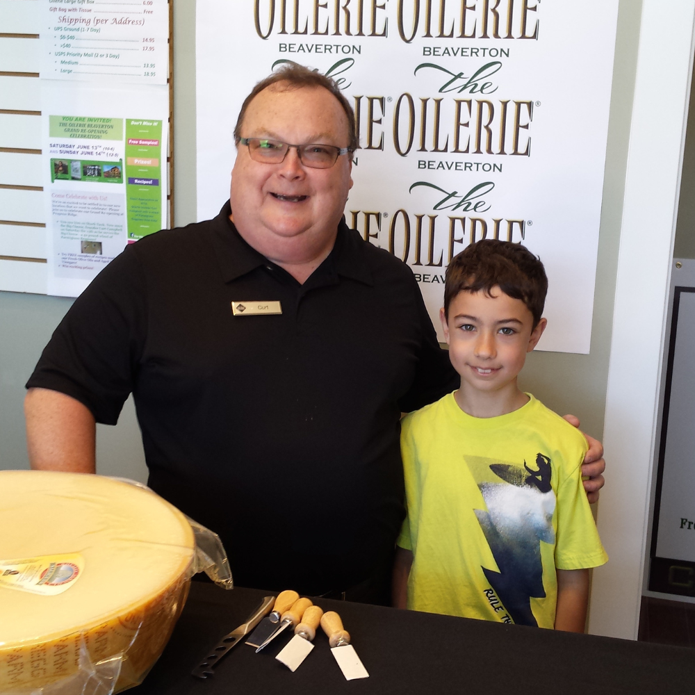 Due persone sorridenti posano davanti a un grande formaggio a una fiera del cibo a Egg Harbor, WI.