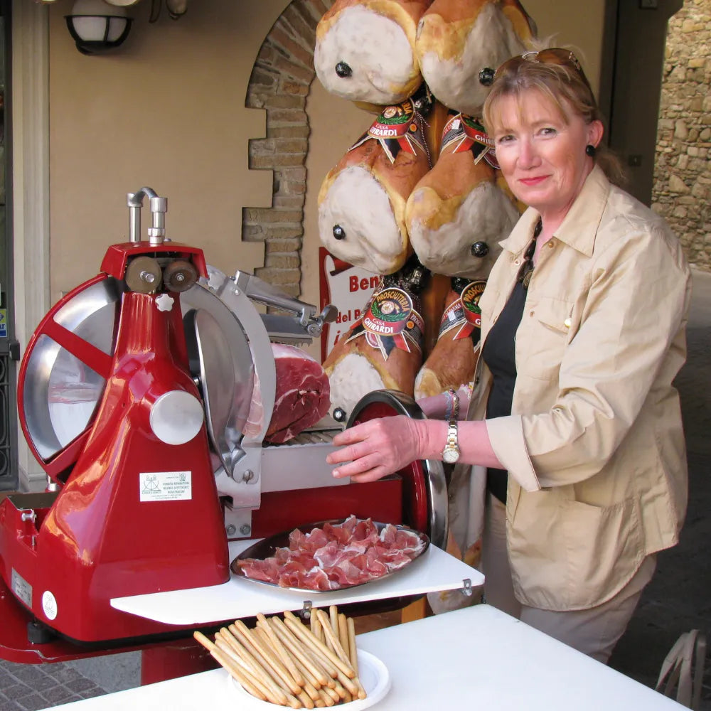 Roberta di ParmaShop mentre affetta del Prosciutto di Parma.