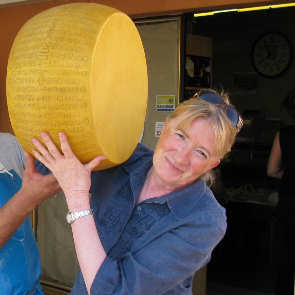 Roberta con una forma di Parmigiano-Reggiano, simbolo di tradizione e gusto italiano autentico.