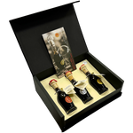 Scatola di velluto nero aperta contenete tre bottigliette di Aceto Balsamico Tradizionale di Modena DOP con vista laterale.