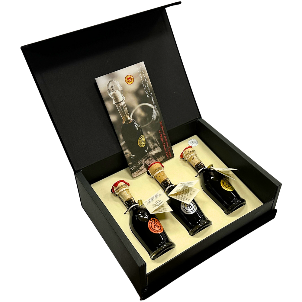 Scatola di velluto nero aperta contenete tre bottigliette di Aceto Balsamico Tradizionale di Modena DOP con vista laterale.