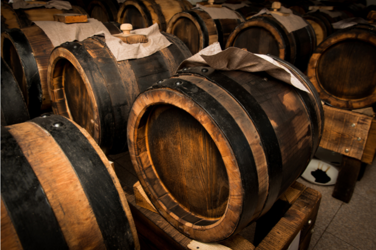 Botticelle di legno di aceto balsamico, che invecchiano in un ambiente rustico per esaltare il sapore autentico di Reggio.